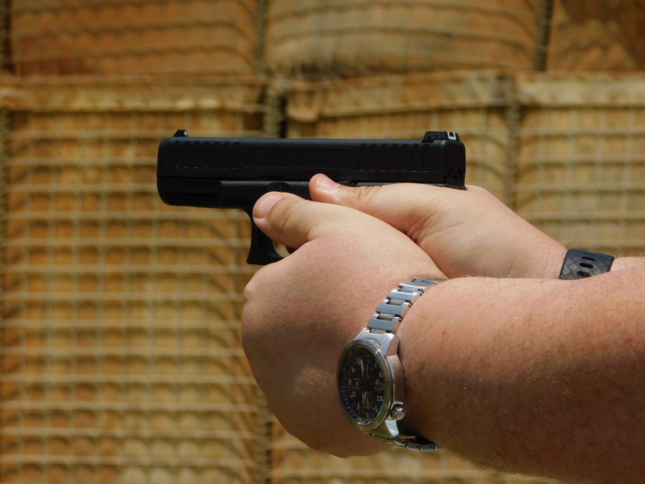 Author firing the Glock 44 in a two-handed grip at the range.